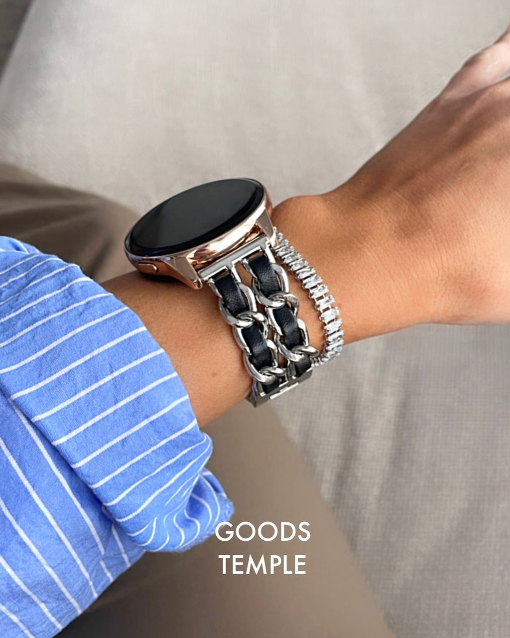 Person wearing a smartwatch and bracelet on a neutral background with 'GOODS TEMPLE' branding.