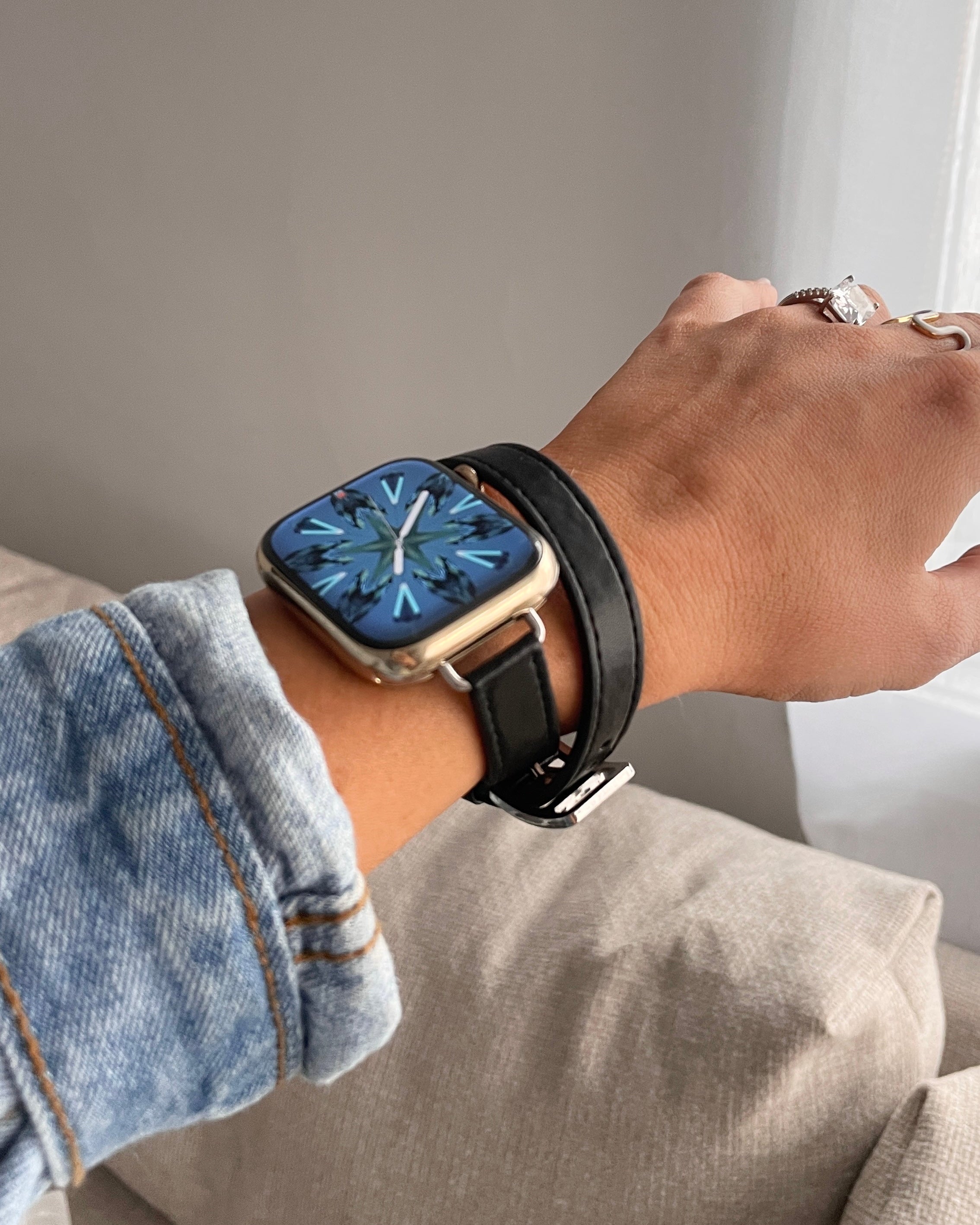 Person wearing a smartwatch with a black strap on a neutral background