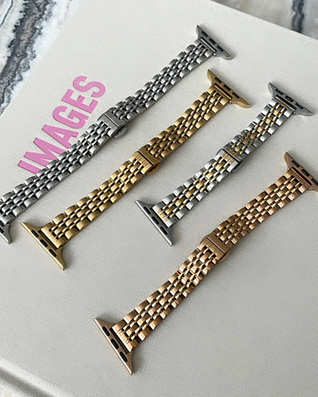Set of metal watch bands on a white surface with 'IMAGES' branding.