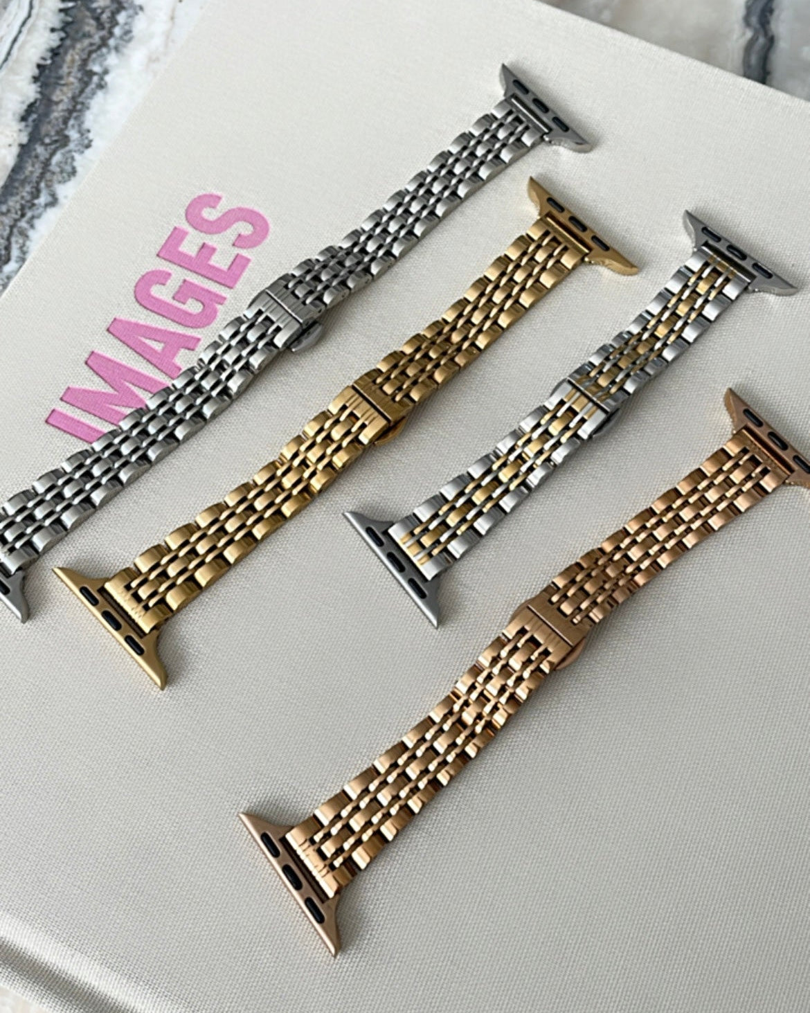 Set of metal watch bands on a white surface with 'IMAGES' branding.