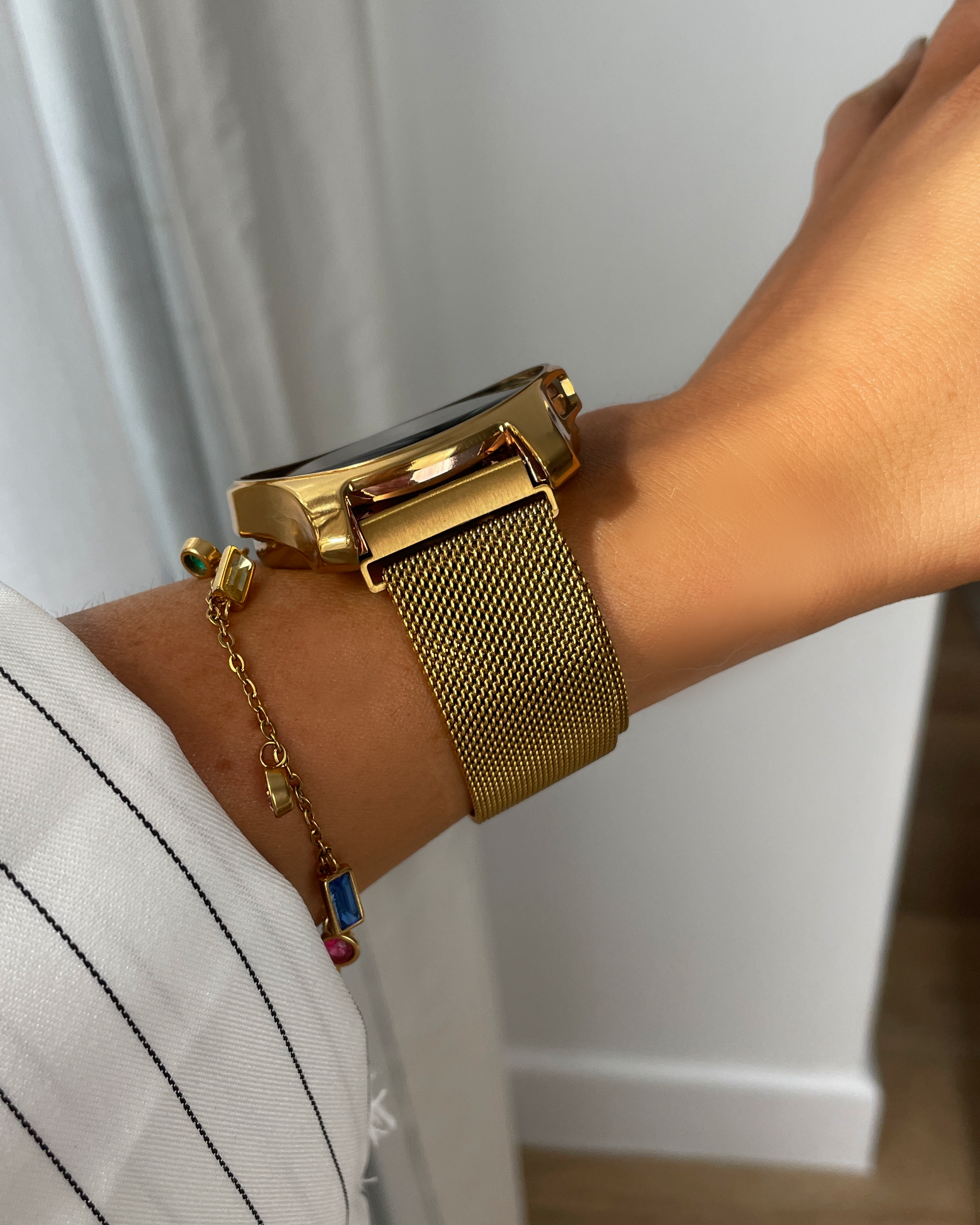 Gold watch on a wrist with a white background