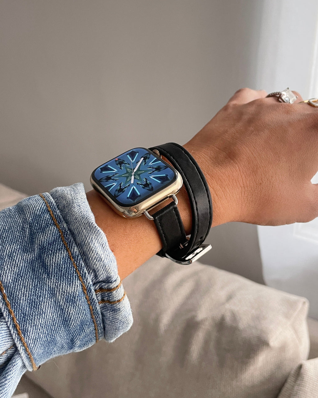 Person wearing a smartwatch with a black strap on a neutral background