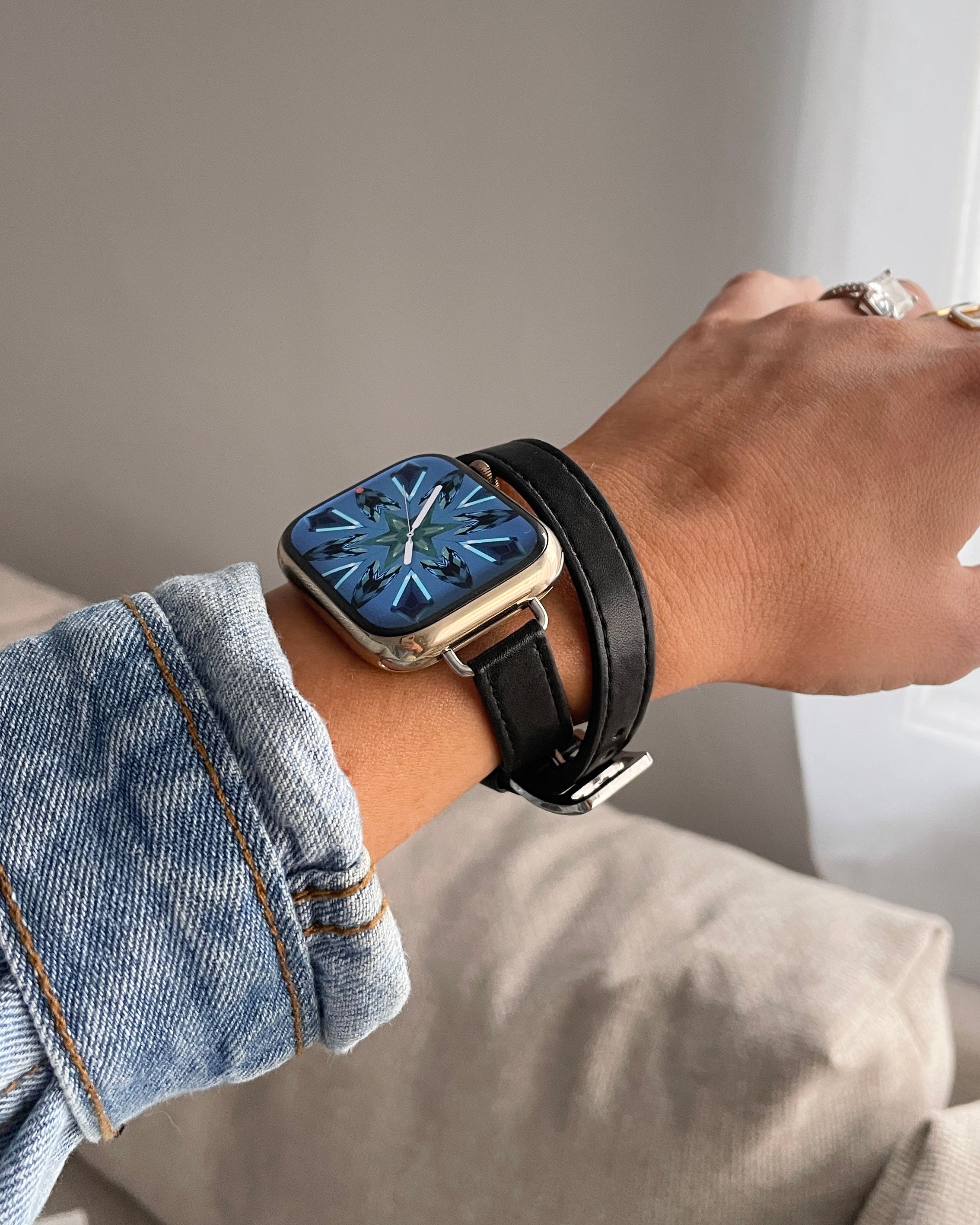 Person wearing a smartwatch with a black strap on a neutral background