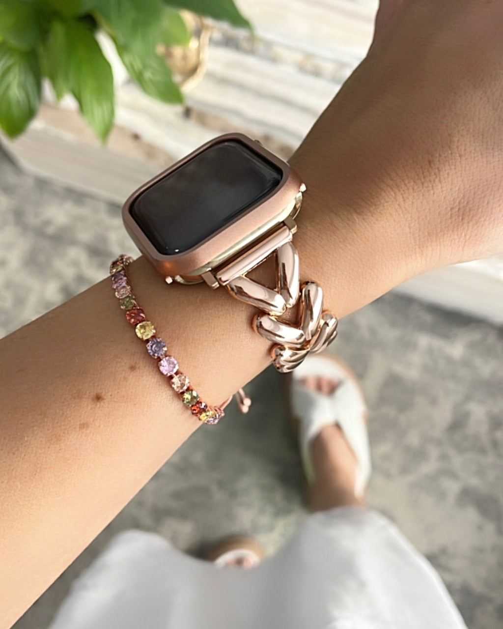 Smartwatch on a wrist with a colorful bracelet, blurred background