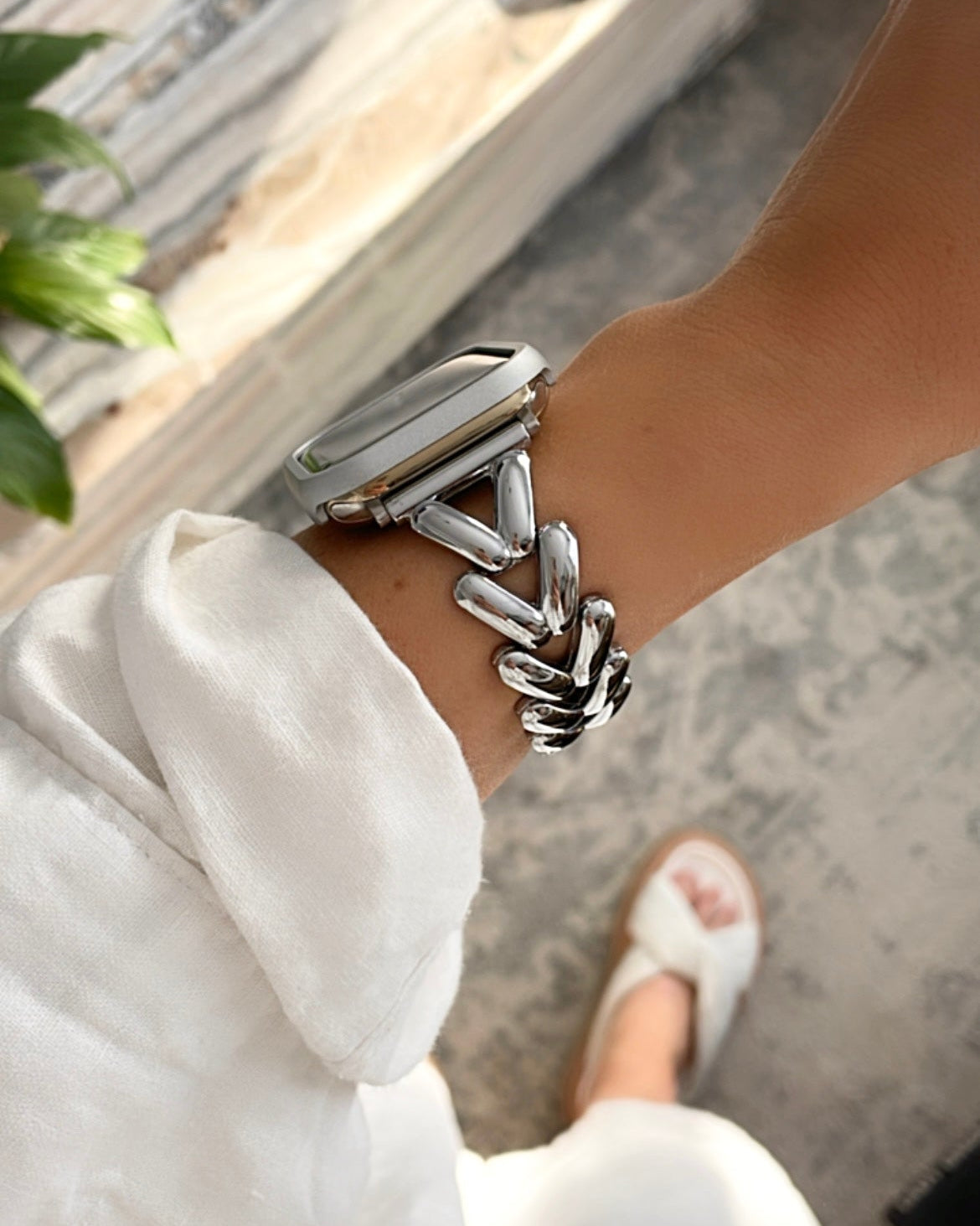 Silver bracelet on a wrist with a blurred background