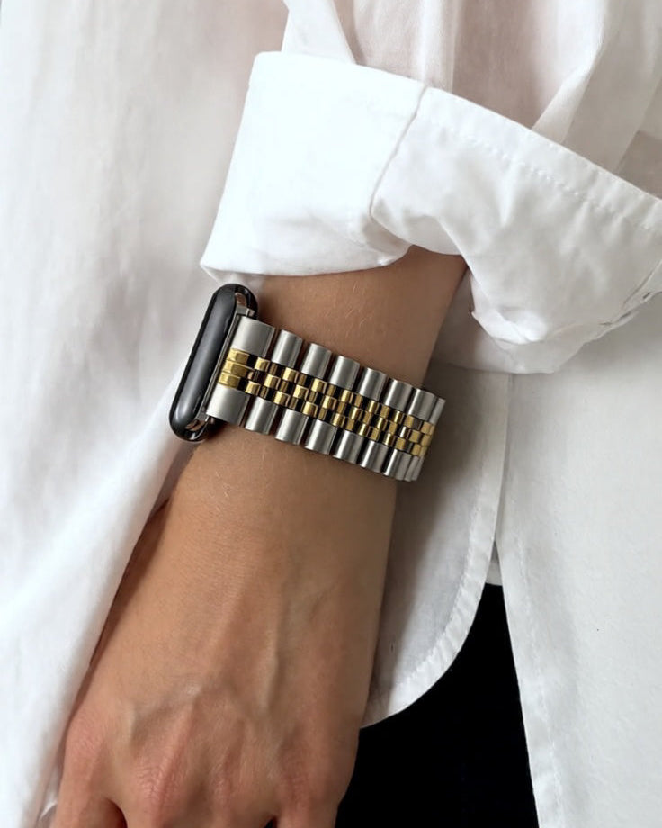 silver and gold jubilee watch on a wrist with a white shirt background