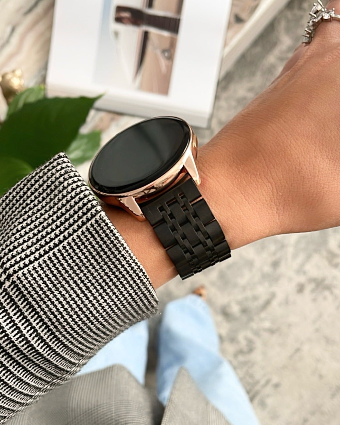 Person wearing a smartwatch with a black band on a blurred background