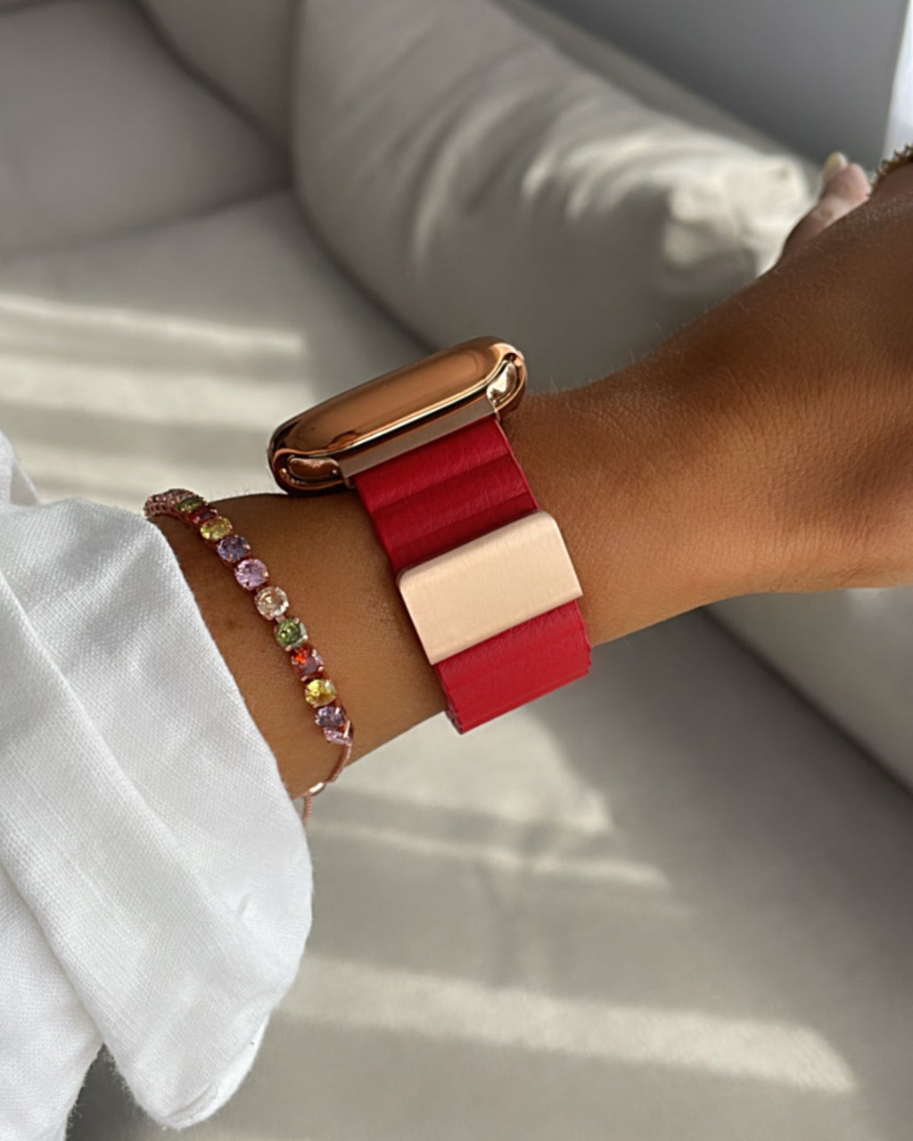 Close-up of a wrist wearing a colorful bracelet on a light background