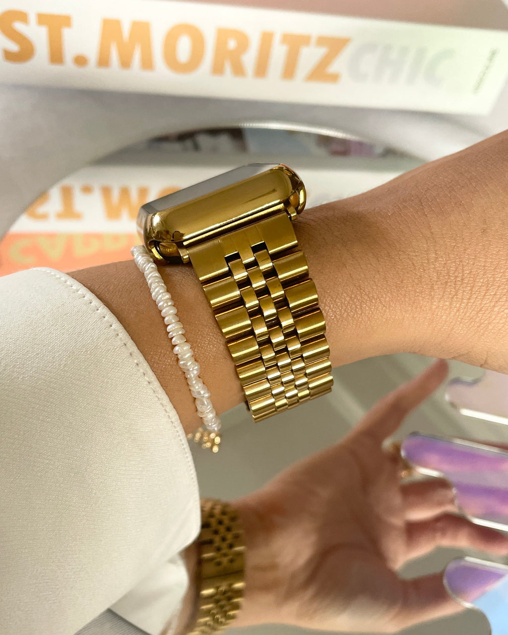 Gold watch on a wrist with a blurred background