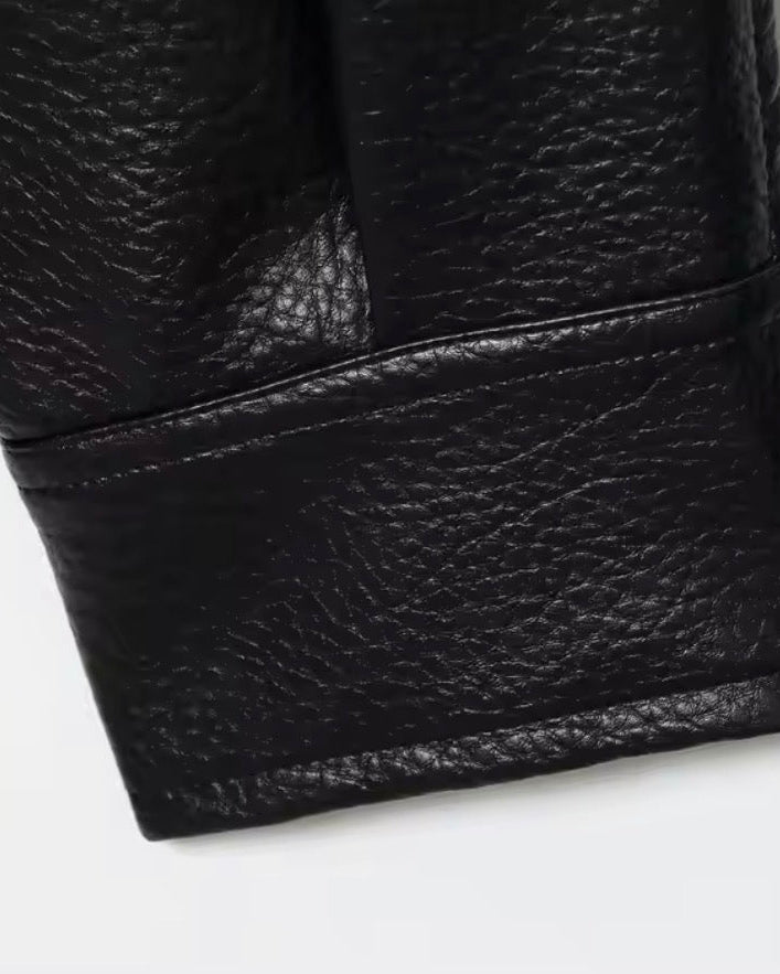 Close-up of a black leather glove on a white background