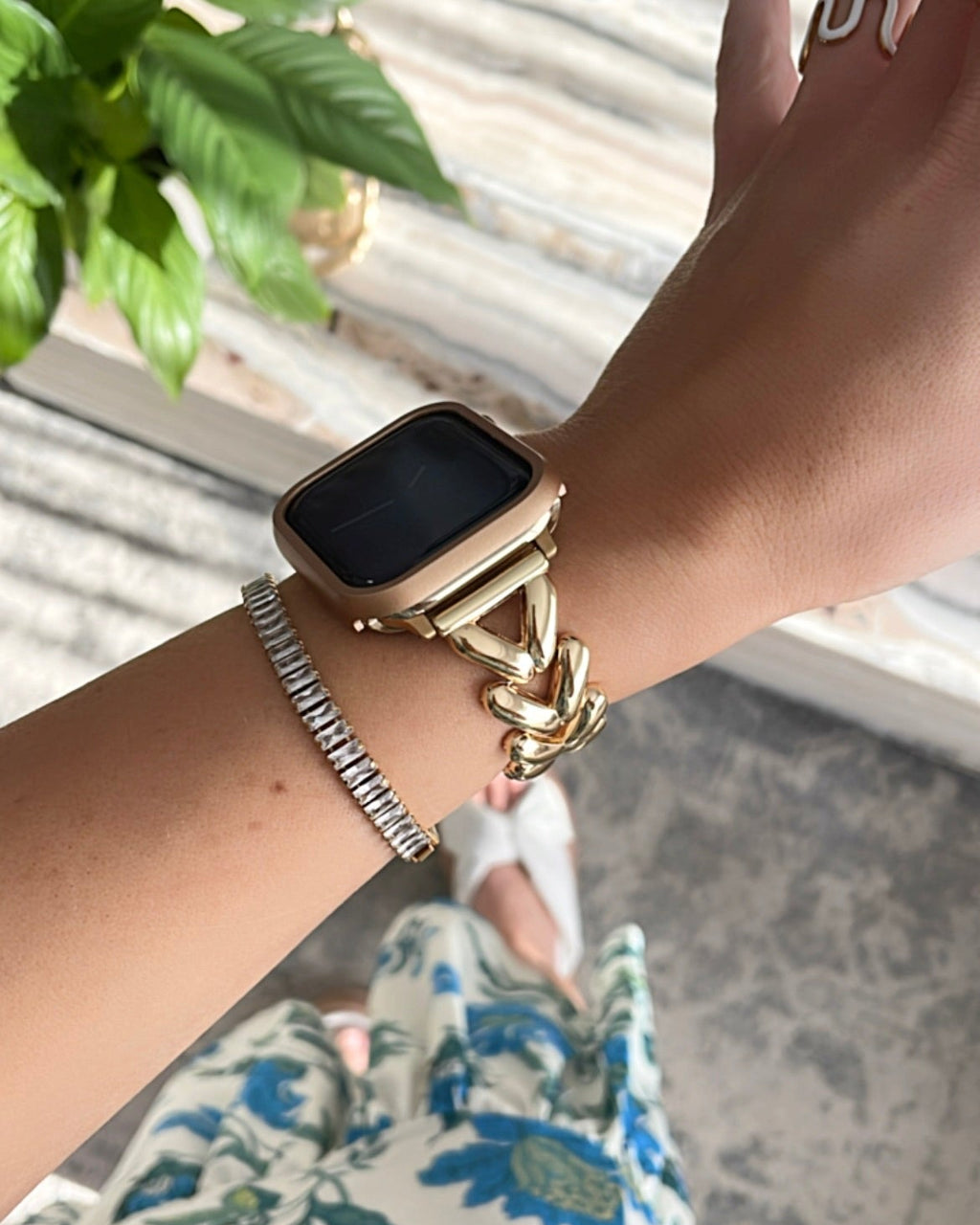 Gold smartwatch on a wrist with a blurred background