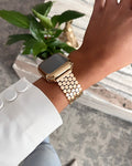 Gold watch on a wrist with a blurred background
