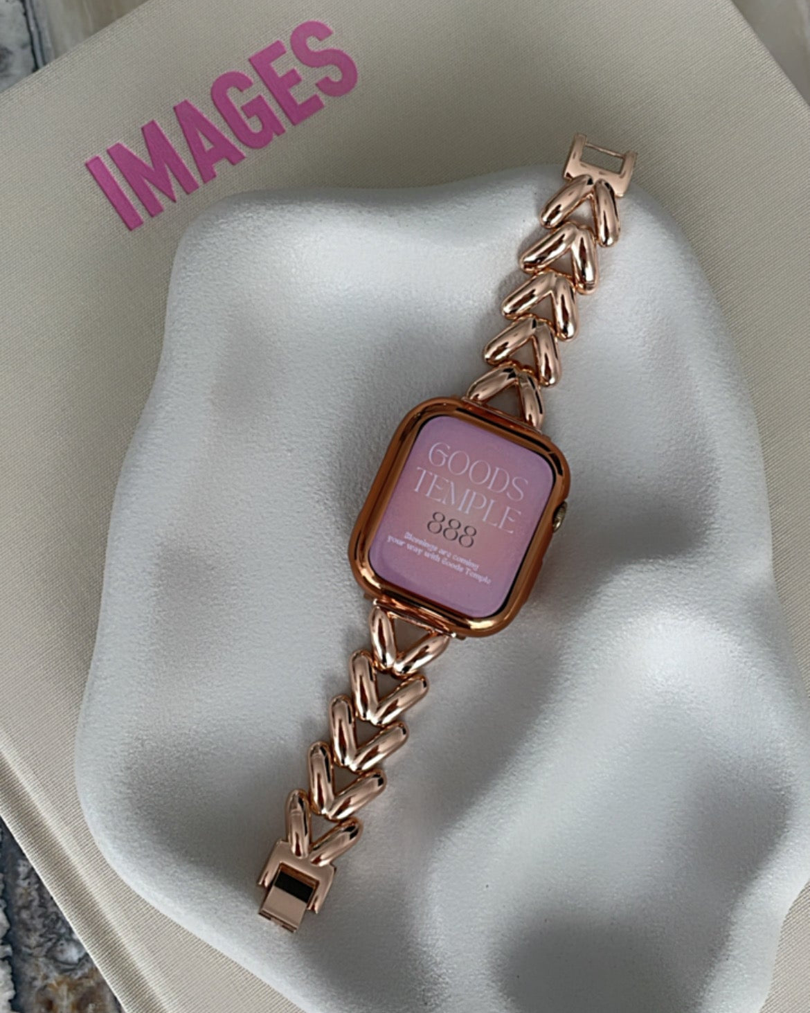 Smartwatch with a gold chain strap on a white surface, branded 'Images'.