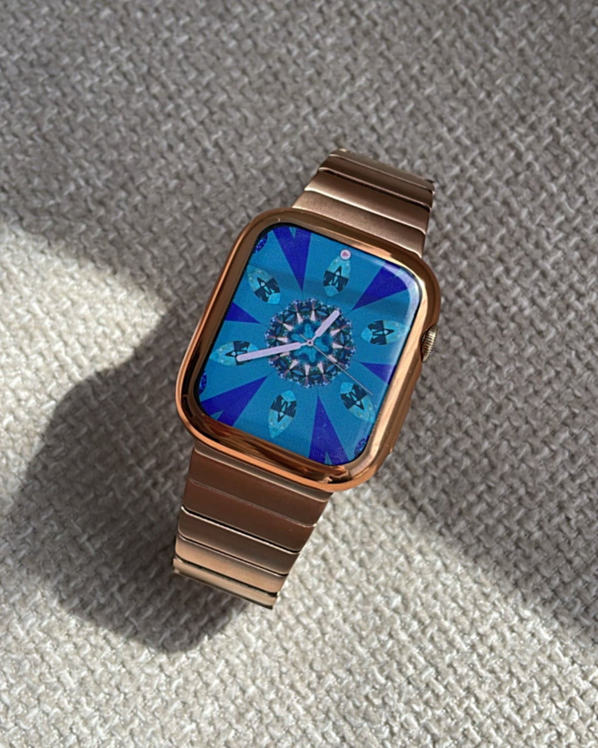 Wristwatch with a blue face and brown metal band on a textured surface