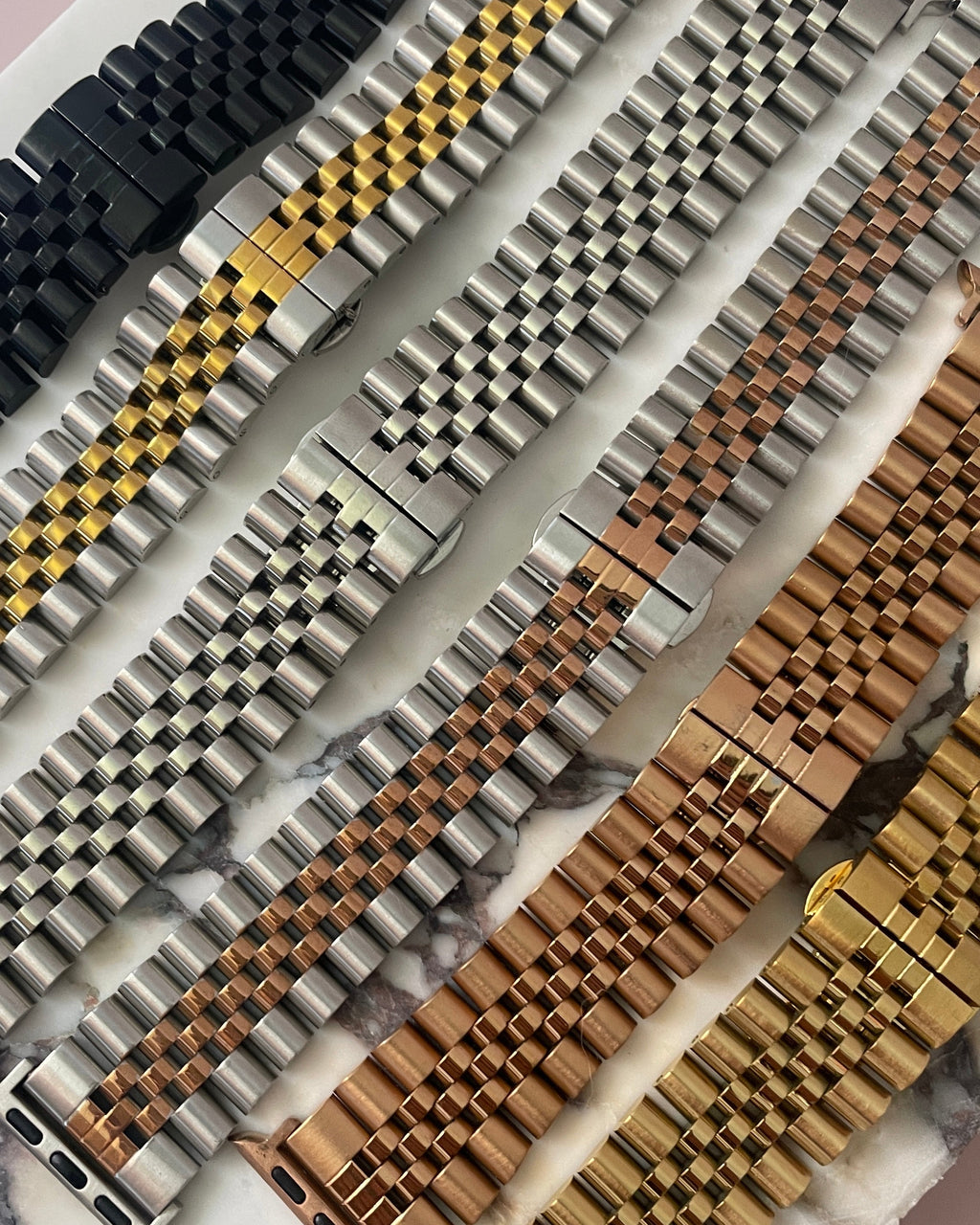 Collection of various watch straps on a marble surface