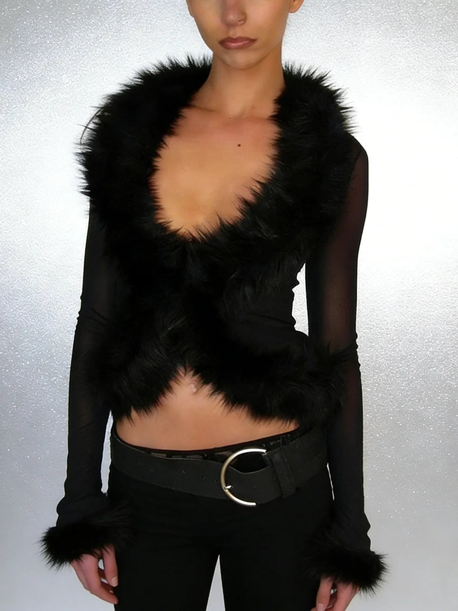 Black fur-trimmed garment worn by a person on a gray background