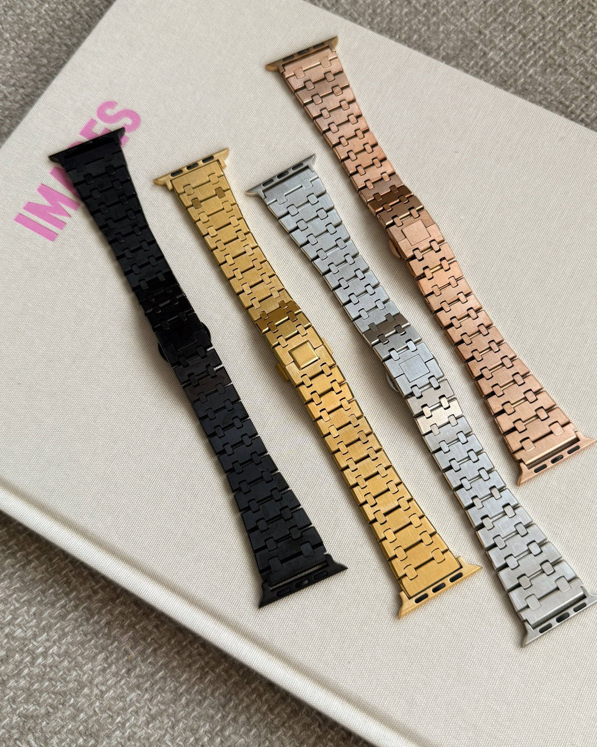 Set of five watch straps in different colors on a white surface.