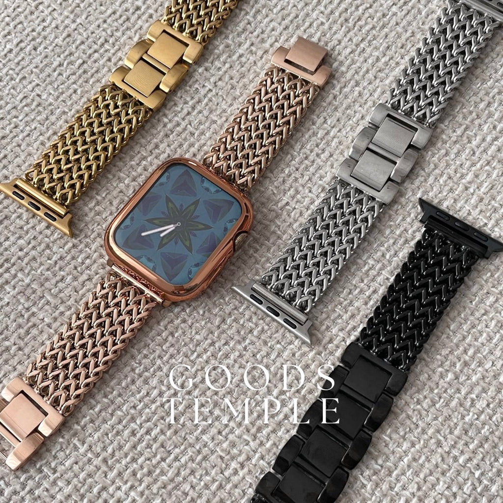 Watch with gold, silver, and black mesh bands on a textured surface with 'GOODS TEMPLE' branding.