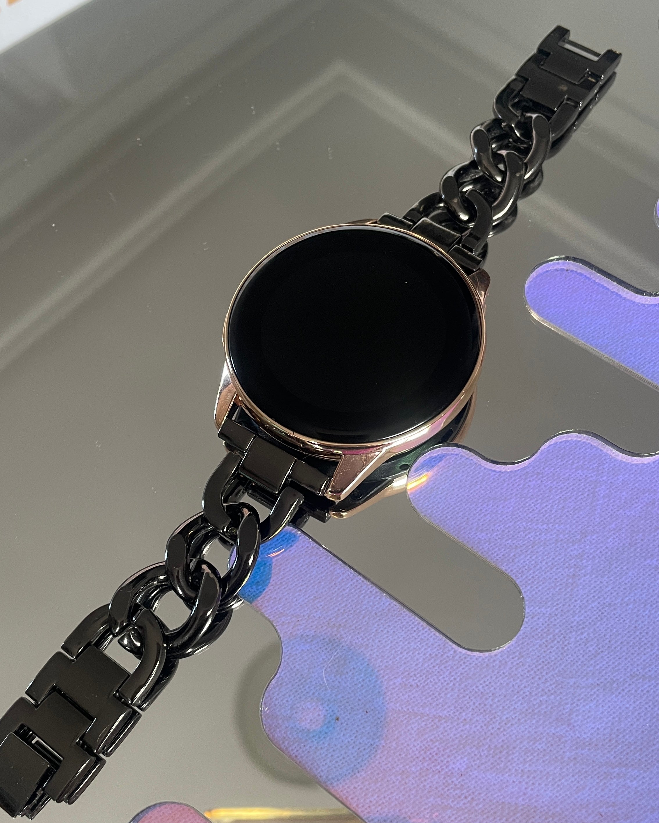 Black chain bracelet on a reflective surface