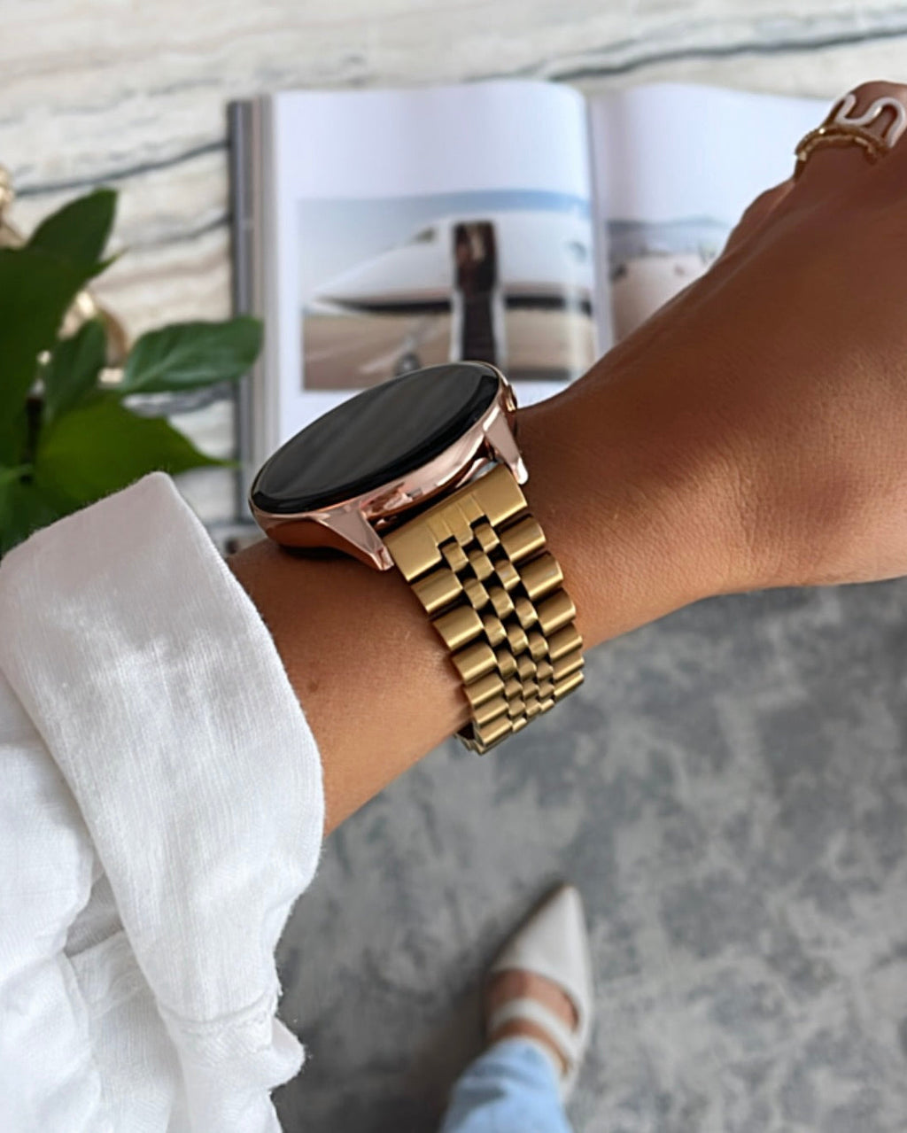 Gold watch on a wrist with a blurred indoor background