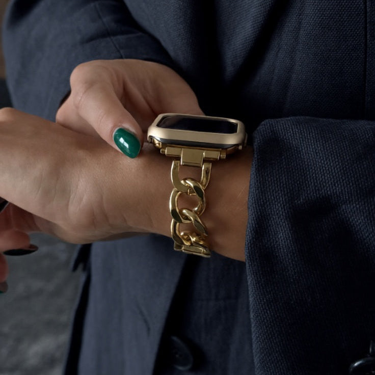 Person wearing a gold watch with a dark background