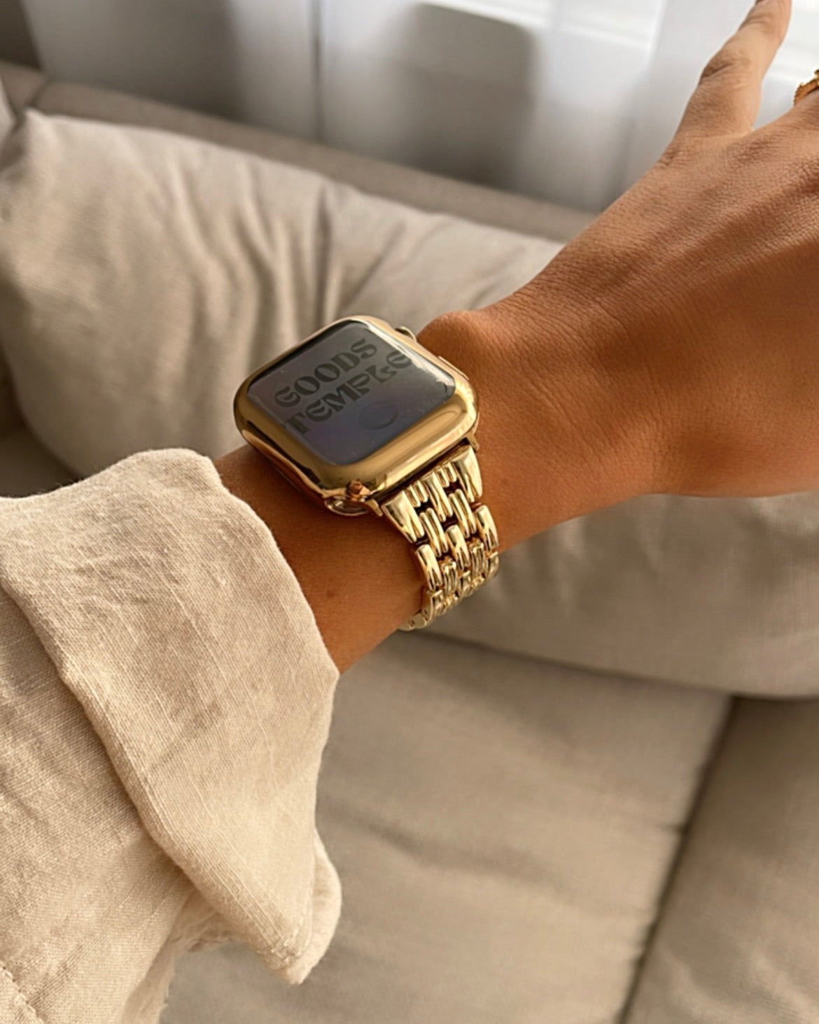 Gold smartwatch on a wrist with a blurred background