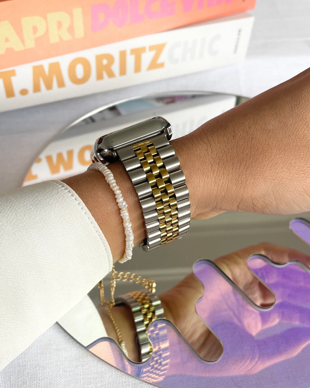 Close-up of a hand wearing a gold watch with a blurred background