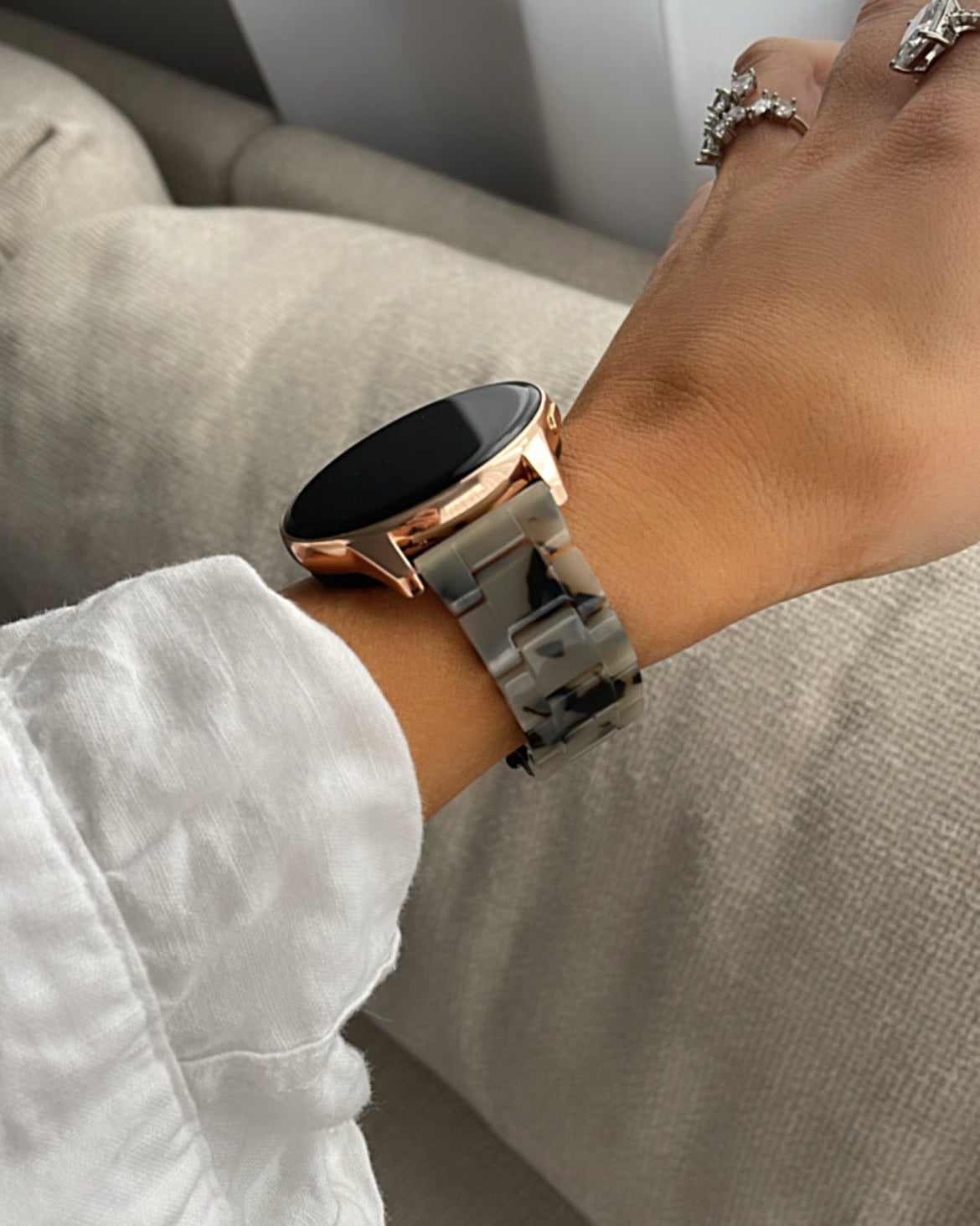 Person wearing a smartwatch on a light-colored couch