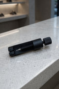 Black tool on a light gray countertop with a blurred background