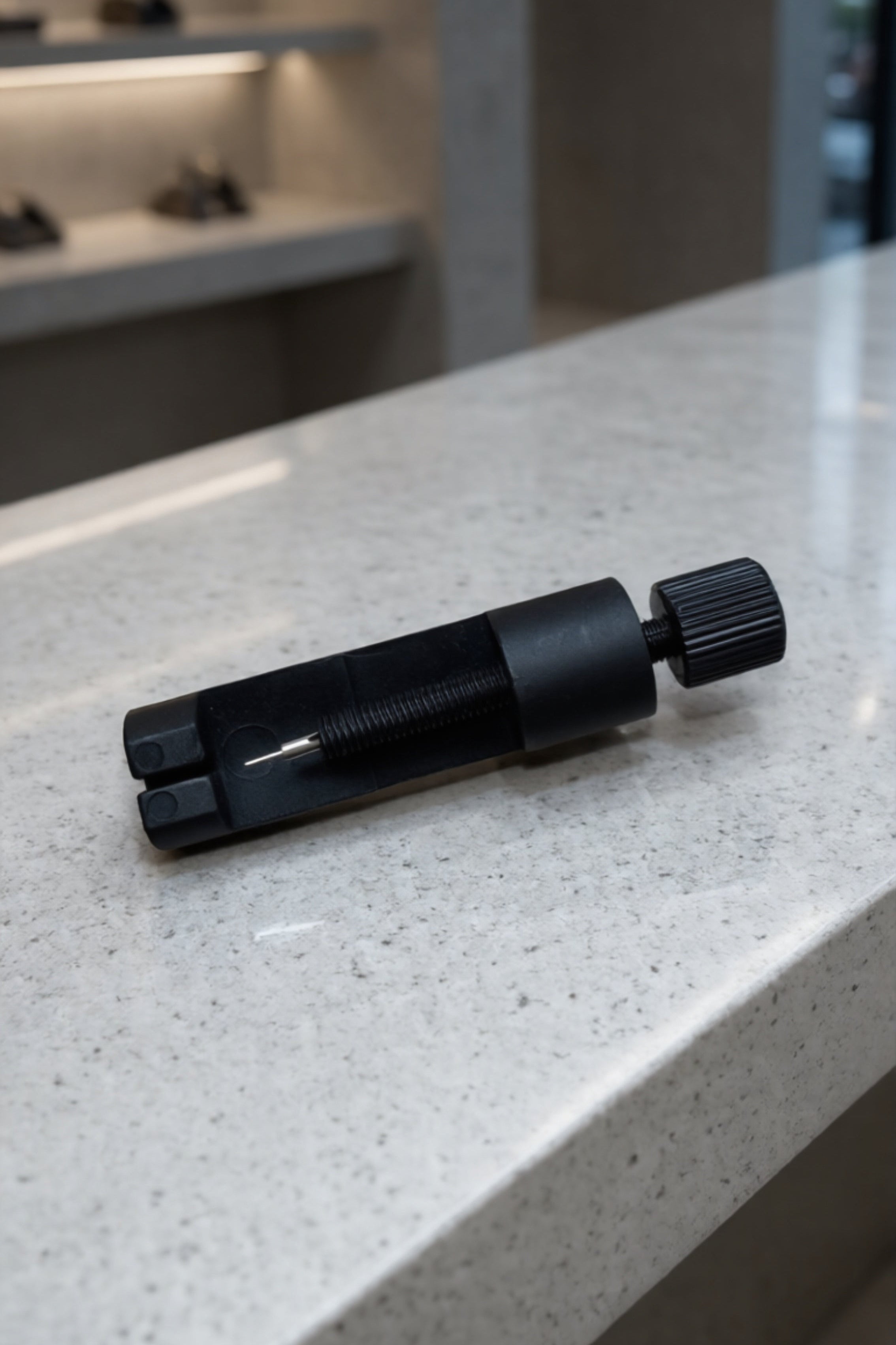 Black tool on a light gray countertop with a blurred background