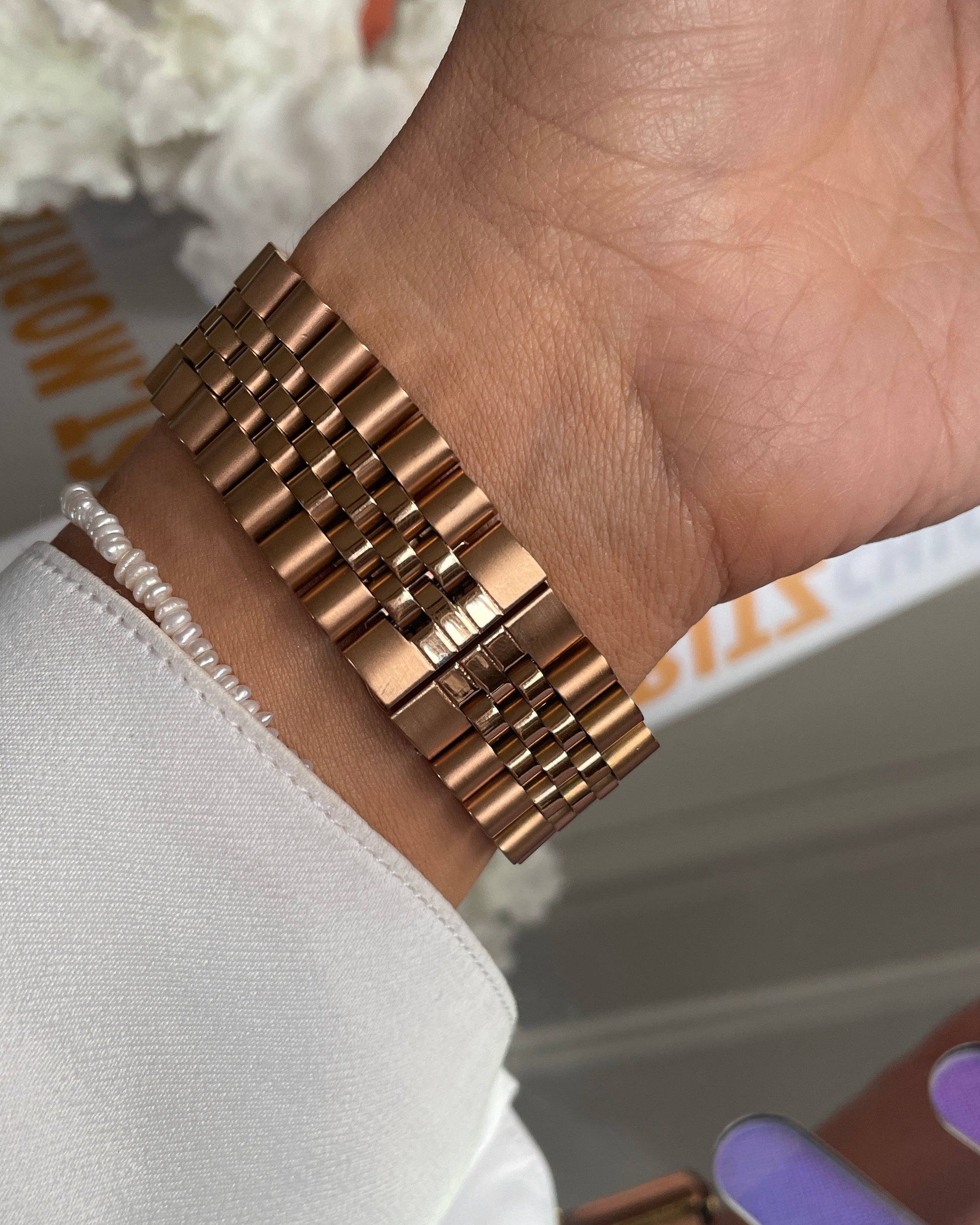 Rose gold bracelet on a wrist with a blurred background