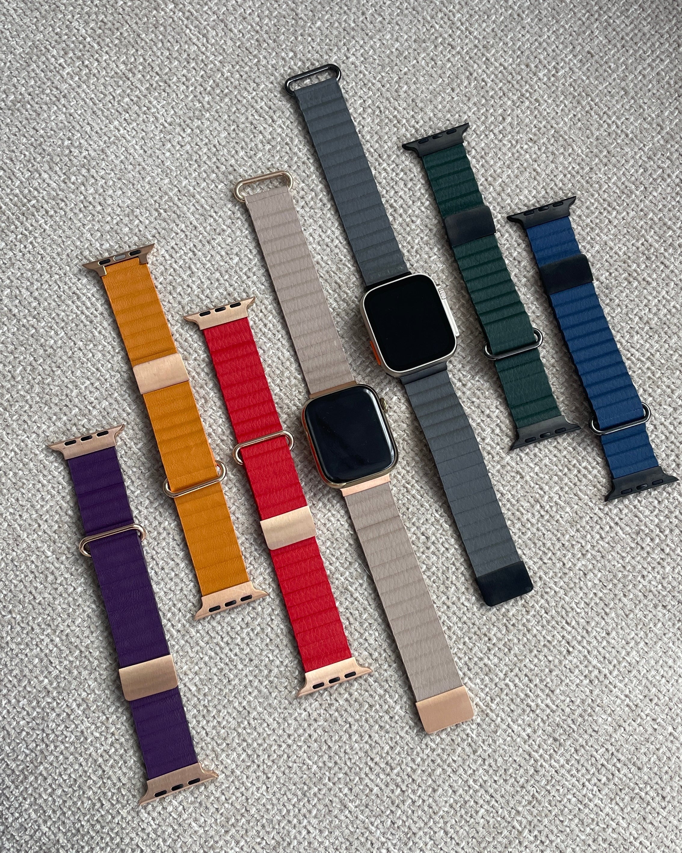 Collection of various watch straps on a textured surface