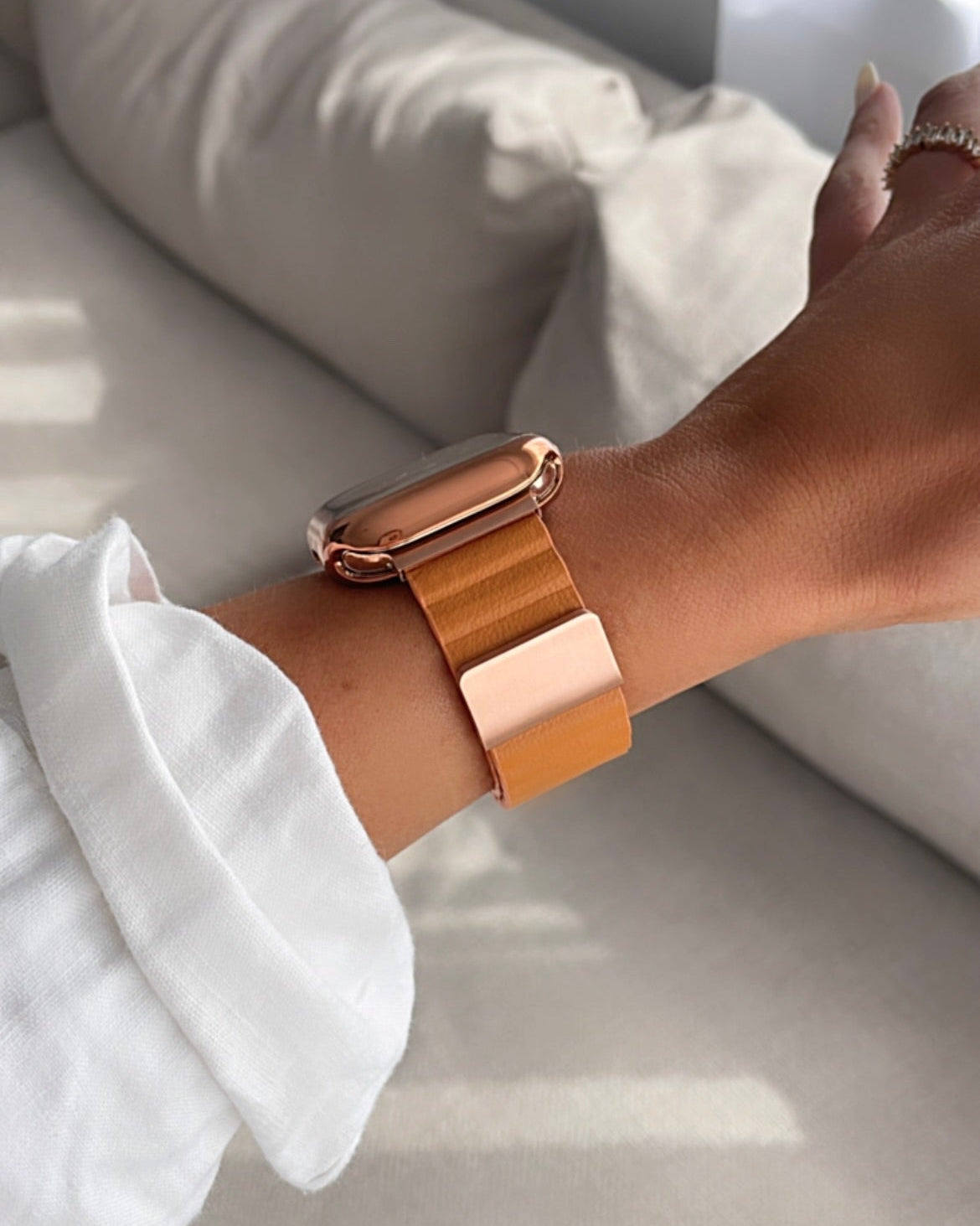 Rose gold watch on a wrist with a blurred background