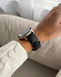 Smartwatch with a black strap on a wrist, blurred background