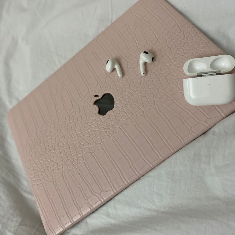 Pink crocodile-textured laptop case with  logo on a white surface