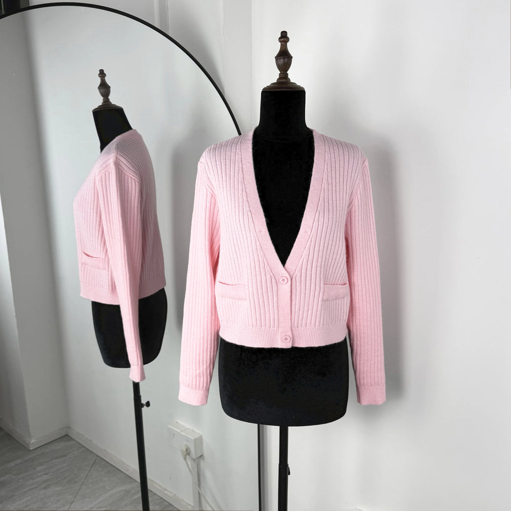Pink ribbed cardigan on a mannequin against a white background