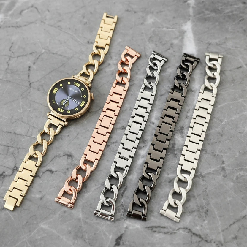 Set of metal watch straps in gold, rose gold, silver, and black on a magazine background.