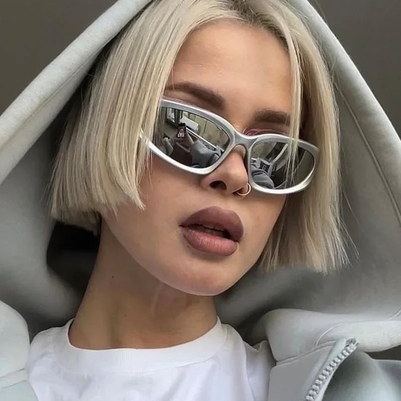 Person with blonde hair and sunglasses inside a car.