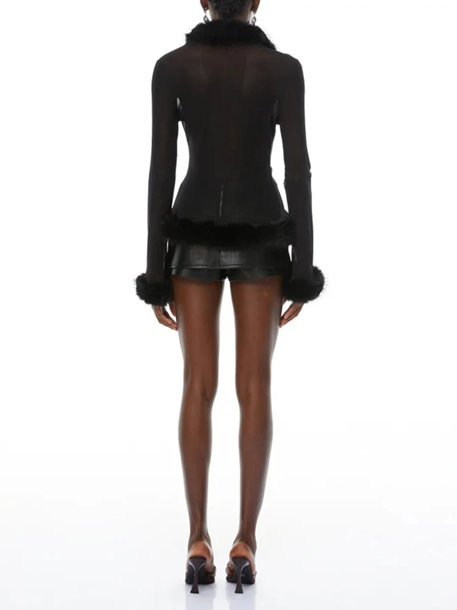 Black jacket with fur trim worn by a model on a white background
