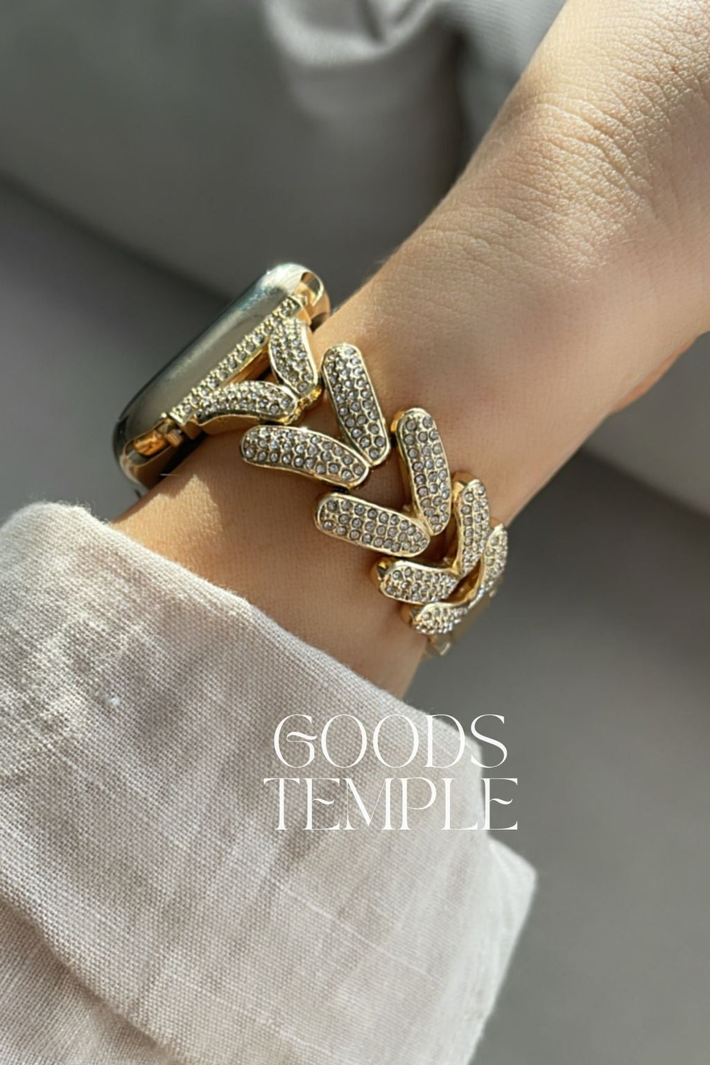 Gold bracelet on a wrist with 'GOODS TEMPLE' branding.