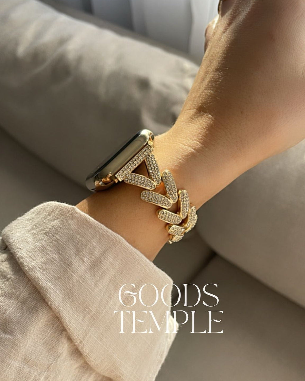 Gold bracelet on a wrist with 'GOODS TEMPLE' branding.