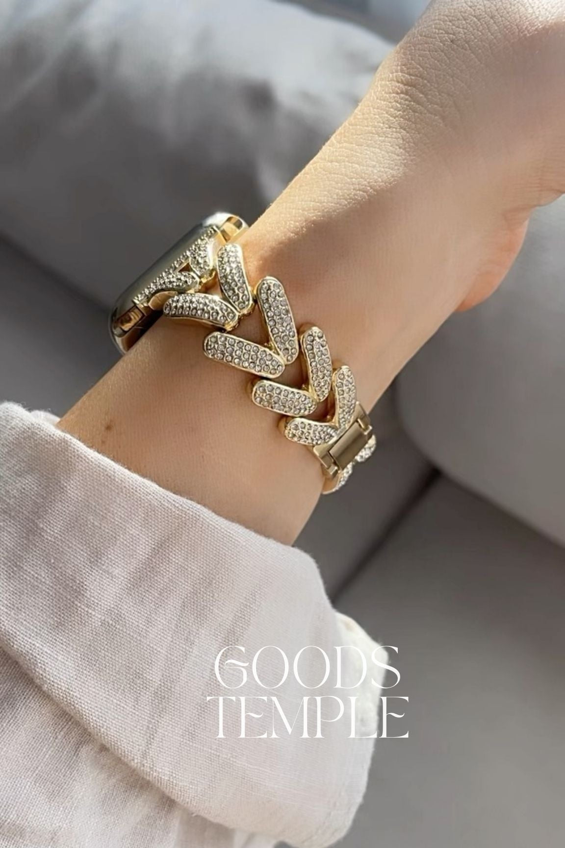 Gold bracelet on a wrist with 'GOODS TEMPLE' branding.