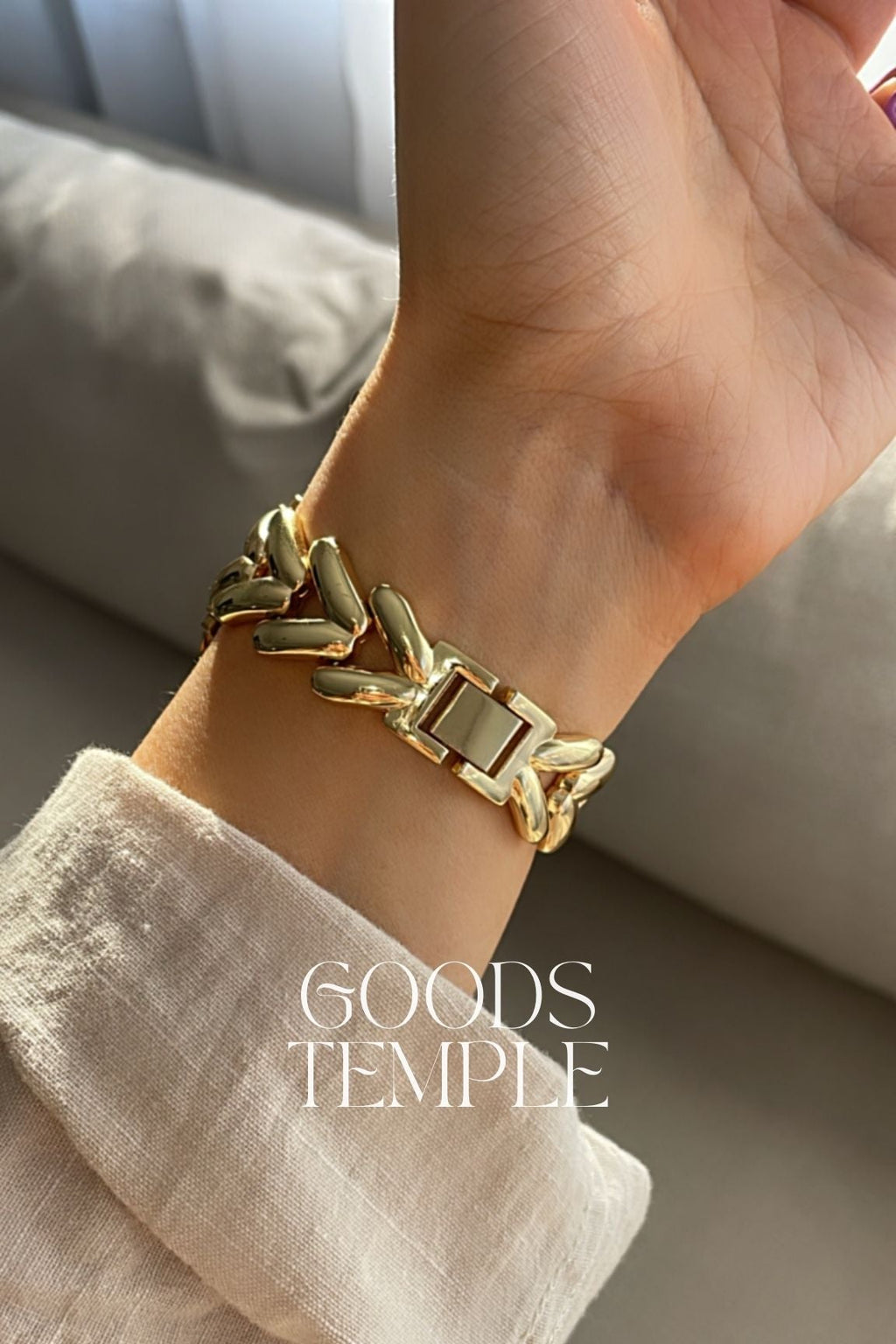 Gold bracelet on a wrist with 'Goods Temple' branding.