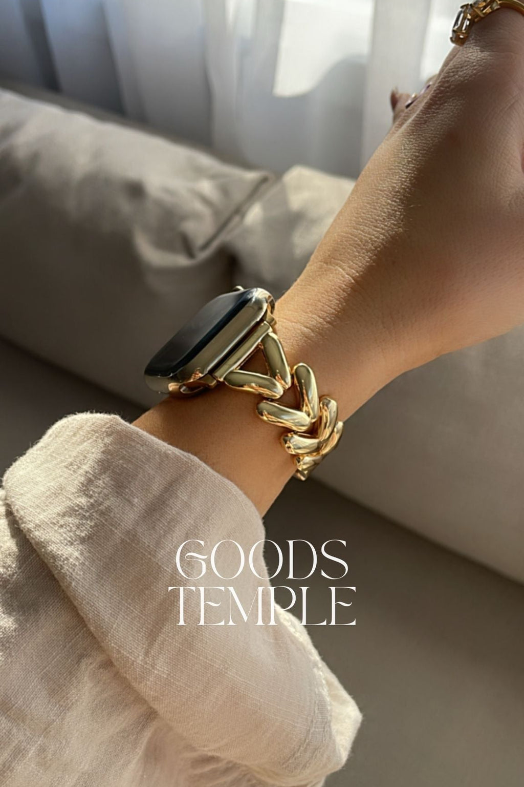 Gold bracelet on a wrist with a blurred background and 'GOODS TEMPLE' branding.
