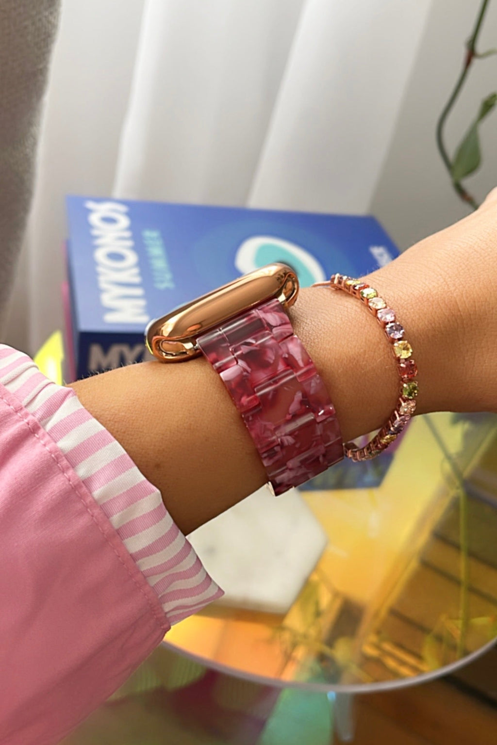 Close-up of a wrist wearing a pink bracelet with a blurred background