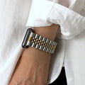 silver and gold jubilee watch on a wrist with a white shirt background