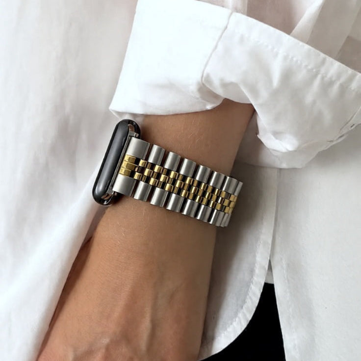 silver and gold jubilee watch on a wrist with a white shirt background